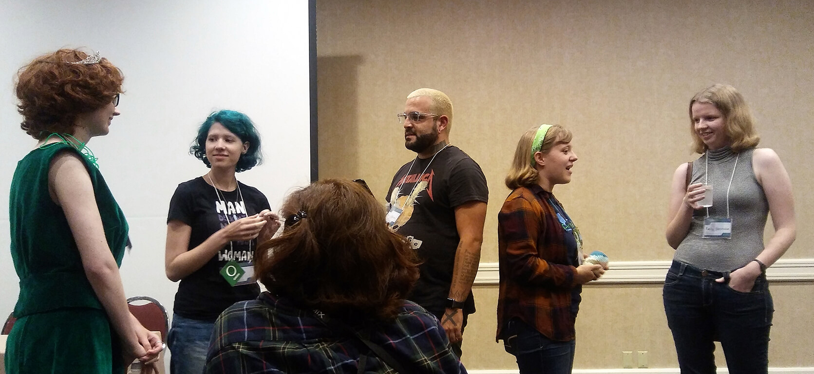 Several attendees chatting with Mark Oshiro and Emily
Skrutskie